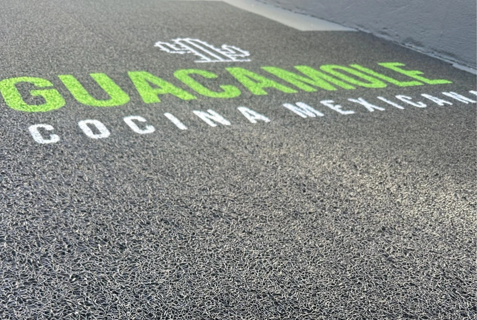 Tapete personalizado com logomarca Guerma Tapetes instalado na entrada de empresa, destacando a marca no campo de visão do visitante.